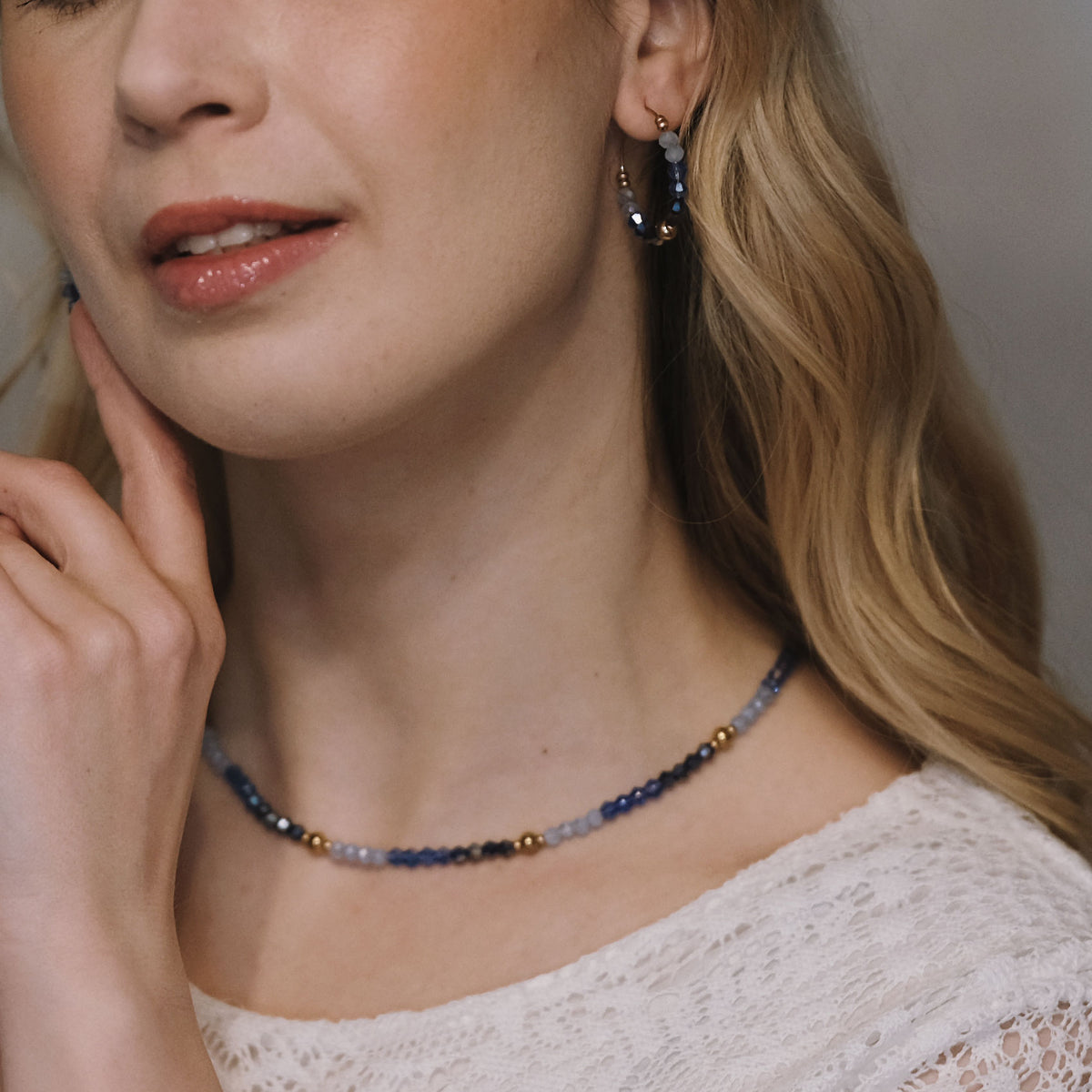 Jolie Sapphire -käsintehdyt korvarenkaat vaalean ja syvän sinisillä helmillä sekä kullanvärisellä renkaalla.