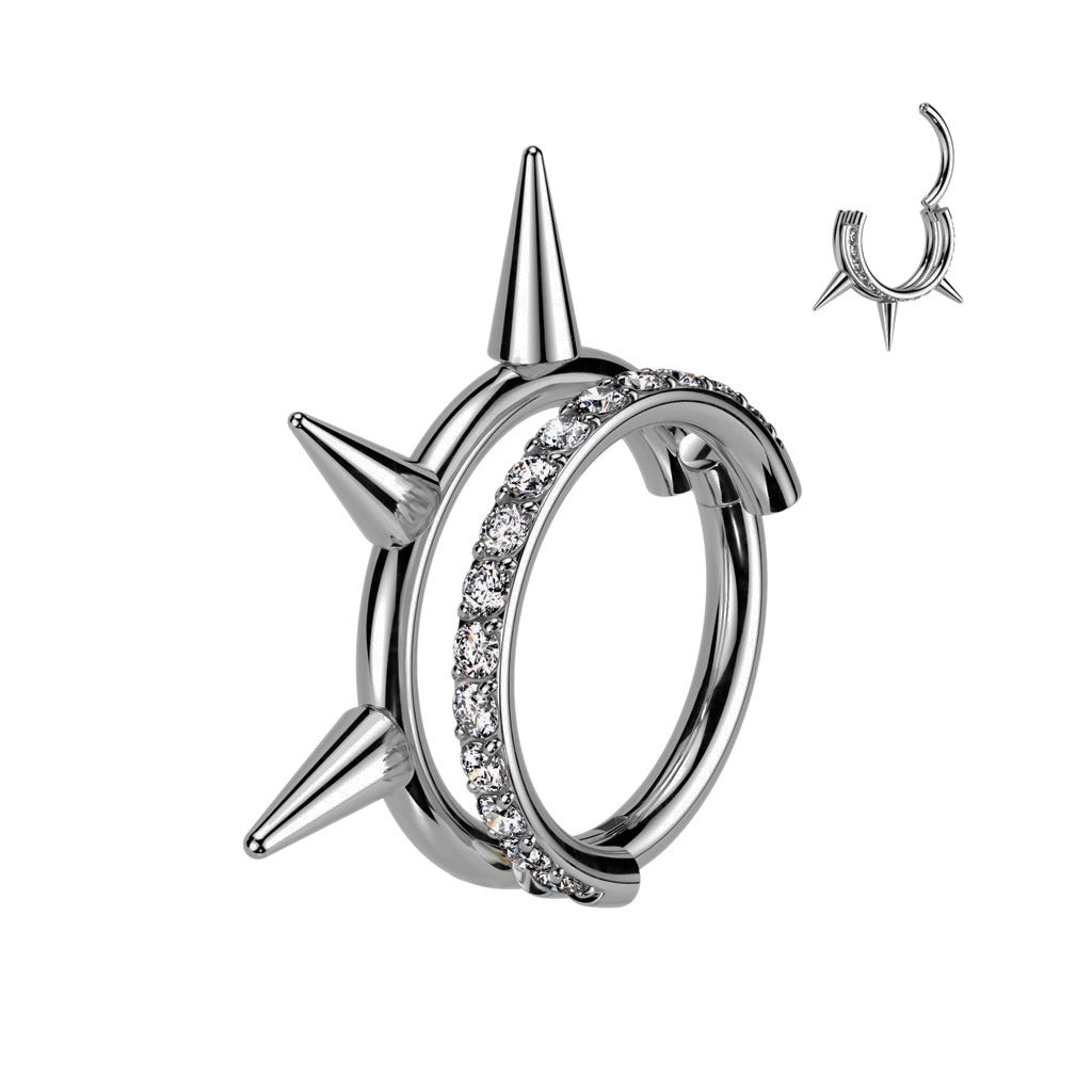 Hopeanvärinen Rhea-titaanilävistysrengas, jossa rinnakkaiset kaaret, kirkas Cubic Zirconia -kivirivi ja kolme piikkiä.